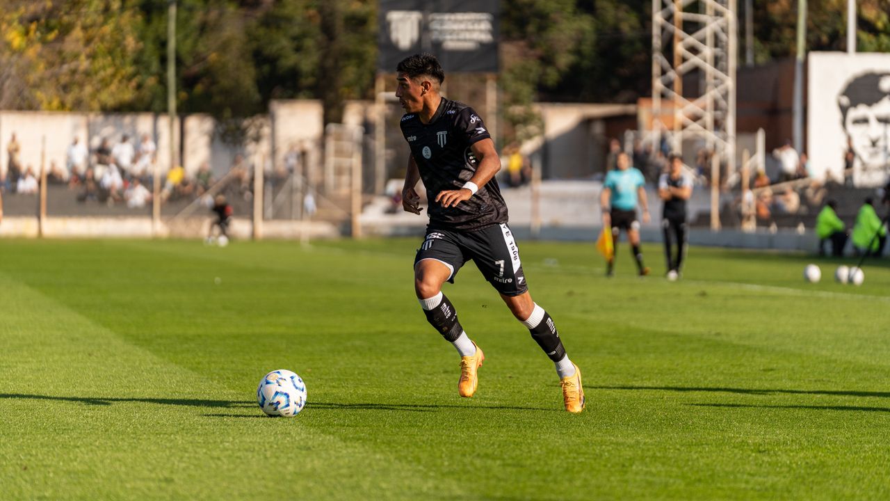 about-us Soccer player dribbling the ball during a daytime match outdoors.